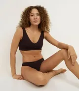 Soutien tipo bralette confeccionado en poliamida con tecnología seamless, de escote en V y breteles anchos fijos. Diseño liso sin aros ni relleno, con etiqueta de la marca Lov en el frente.