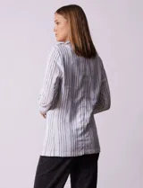 Blazer blanco con rayas verticales negras, cuello con solapa, abertura central con botón y bolsillos delanteros.