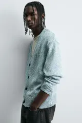 Cárdigan de punto con mezcla de algodón, de corte relajado y cuello en pico. Presenta un diseño con efecto de roturas y acabado jaspeado en tonos azul y blanco, con cierre frontal de botones y puños y bajo en rib.