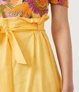 Short femenino modelo clochard, confeccionado en una mezcla de viscosa, lino y algodón. Presenta un diseño de tiro alto con cintura elástica y lazo ajustable del mismo tejido, ofreciendo un calce cómodo y versátil.