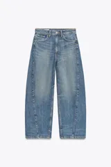 Jeans de tiro medio con diseño baggy barrel, cinco bolsillos y costuras laterales torcidas. Presenta cierre frontal con cremallera y botón metálico.