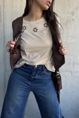 Remera beige de algodón con detalle de bordado floral en el pecho en tonos marrones y crudos.