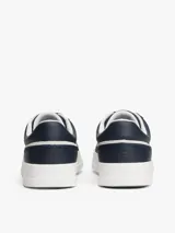 Zapatillas de tenis Tommy Hilfiger de corte bajo, confeccionadas en piel napa color azul marino con paneles laterales en contraste color blanco. Presentan cierre con cordones, suela de goma blanca y logo de la marca grabado en el lateral y el talón.