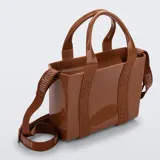 Cartera bandolera tipo tote de material sintético flexible color marrón, con doble asa superior y correa ajustable y removible con inscripciones de la marca.