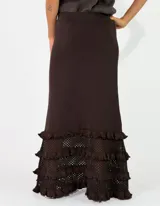 Pollera larga de punto color negro, con diseño ajustado en la parte superior y detalles de volados con textura en el ruedo.