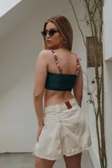 Minifalda de gabardina color marfil, con diseño de tablas y costuras pespunteadas en contraste.