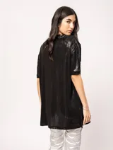 Remera blanca oversized de tela elastizada con tajos laterales y escote redondo.