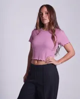Remera de morley de algodón en color rosado, con corte ajustado, cuello redondo y mangas cortas con terminación fruncida en los bordes.
