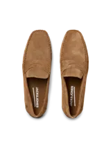 Mocasín de cuero gamuzado color marrón claro, con punta redonda y detalle de costuras a la vista.