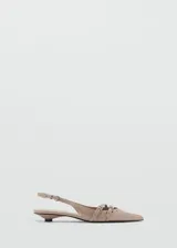 Zapato color beige con punta, cierre de hebilla, detalles troquelados y tacón kitten.