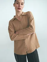 Cardigan de punto color tostado, con cuello camisero, cierre frontal de botones y mangas largas.