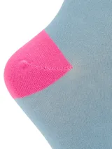 Medias de bambú de caña media, color celeste con talón y puntera en fucsia, y detalle de logo de pato bordado en el puño.
