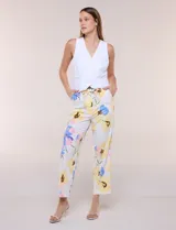 Pantalón ankle de sastrería color blanco con estampado floral multicolor, de corte recto y tiro medio con cordón de ajuste en la cintura.