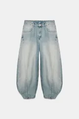 Jeans de mezclilla de tiro medio con diseño amplio tipo balloon, costuras marcadas y bajo con puño elástico. Cuenta con bolsillos delanteros y traseros, y cierre frontal con cremallera y botón metálico.