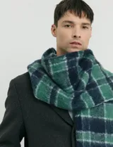 Bufanda de estilo escocés con textura suave, diseño a cuadros en tonos azul y verde, con flecos en los extremos.