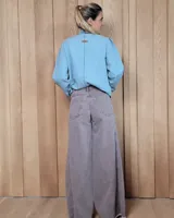 Pantalón de jean azul de tiro medio, con corte wide leg y ruedo deshilachado.