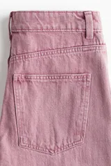 Jean de tiro alto con pierna amplia y corte holgado. Confeccionado en denim de algodón, presenta bolsillos delanteros con solapa y cierre de botón.