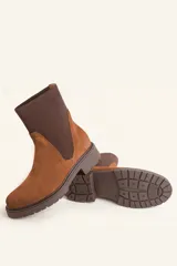 Bota tipo chelsea de gamuza color marrón, con paneles laterales elásticos acanalados y suela de goma track con taco bajo.