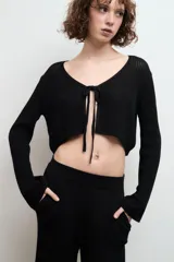 Cardigan negro corto de tejido de punto con escote en V y lazo de ajuste frontal.