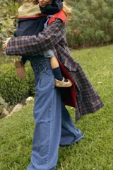 Trench coat reversible de corte recto, con largo por debajo de la rodilla. Un lado está confeccionado en tela impermeable y el otro en viyela suave. Cuenta con bolsillos amplios en ambos lados, lazo de ajuste en la cintura y capucha desmontable.
