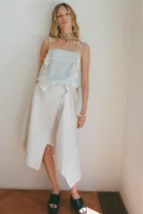 Top celeste con tirantes finos ajustables y escote recto. Detalle de puntilla y bordado floral en el frente.