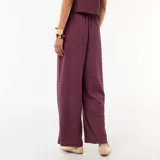 Pantalón ancho color bordó de corte relajado, con cintura elástica fruncida y cordón ajustable.