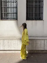 Blazer amarillo de corte sastrero, con solapas de muesca, cierre frontal con botón y bolsillos de ojal.