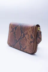 Billetera chica de cuero negro con textura tipo cocodrilo, cierre exterior, bolsillo para monedas con cierre en la parte trasera, múltiples ranuras para tarjetas y billetes, y forro rojo.