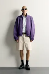 Bermuda relaxed fit color marrón con efecto lavado, cinco bolsillos, bolsillos frontales de carpintero y cierre frontal con cremallera y botón.