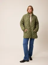 Campera larga acolchada con diseño de rombos, cierre frontal completo y cuello alto. Presenta puños elásticos y un pequeño logo aplicado en el pecho.