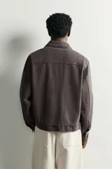 Sobrecamisa regular fit color marrón oscuro efecto lavado, confeccionada en denim de algodón. Cuenta con cuello solapa, manga larga, bolsillos de plastrón en el pecho y cierre frontal con cremallera.