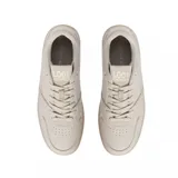 Championes Lacoste modelo L001 Set, color beige monocromático. Presentan un diseño de cuero con textura granulada, cierre de cordones al tono y suela de goma semitransparente con el logo de la marca grabado en el lateral.