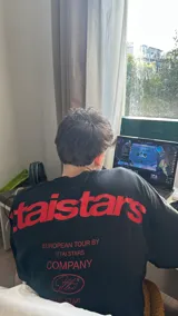 Remera celeste de corte holgado con estampado en rojo en la espalda con el texto "ittaistars", "European Tour by Ittai Stars Company" y el logo de la marca.
