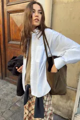 Camisa básica de corte clásico confeccionada en algodón, con cuello solapa, manga larga con puños abotonados, cierre frontal con botones y un bolsillo aplicado en el pecho.