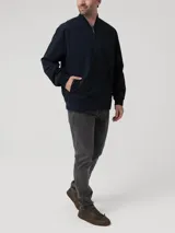 Chaqueta tipo bomber azul marino, con cuello, puños y dobladillo elásticos. Cierre frontal con cremallera y logo bordado en el pecho.