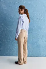 Pantalón de corte recto y holgado, color marrón, con costuras frontales verticales que estilizan la silueta.