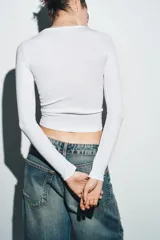 Camiseta de manga larga en color marrón oscuro, confeccionada en tejido de algodón. Presenta un diseño de corte ajustado (slim fit) con cuello redondo.