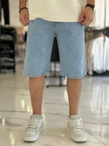 Bermuda de jean de corte baggy y tiro medio, con diseño clásico de cinco bolsillos y lavado claro.