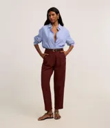 Pantalón carrot de cintura alta y corte zanahoria, color bordó, confeccionado en viscolino con pliegues en el frente y trabillas. Incluye cinturón fino de poliuretano con hebilla.