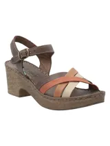 Sandalia de cuero RKF modelo Dalia, con taco alto y plataforma revestidos en textura símil corcho. Posee tiras delanteras cruzadas multicolores en tonos marrón, naranja, tostado y beige, tira en el talón marrón y tira de ajuste al tobillo con hebilla metálica.