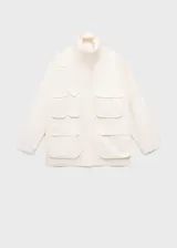 Anorak de estilo utilitario en color crudo, con cuello alto tipo embudo, cierre frontal con cremallera y botones a presión, y múltiples bolsillos de parche con solapa. Presenta un diseño oversize de manga larga.