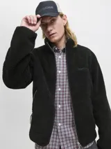 Campera tipo teddy de cuello alto y manga larga, confeccionada en tejido de textura suave. Presenta cierre frontal completo, bolsillos laterales con cierre y un pequeño bordado en el pecho.