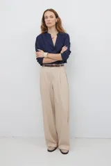 Pantalon de corte recto y pierna ancha, confeccionado en tejido tipo denim oscuro. Presenta tiro alto, cintura con cierre frontal y bolsillos laterales funcionales.