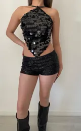 Top negro con lentejuelas, espalda regulable y tirantes finos.