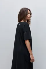 Vestido midi negro de algodón con calce relajado, silueta recta, cuello redondo, mangas cortas amplias y tajos laterales.