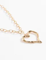 Collar con cadena de eslabones gruesos dorados y dije de corazón calado con textura irregular.