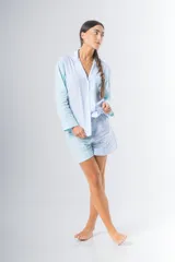 Pijama de algodón a rayas verticales celestes y blancas, compuesto por una camisa de manga larga con botones y un short con elástico en la cintura.