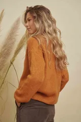 Saco tejido de punto color naranja, con escote redondo, cierre frontal con botones y mangas largas.