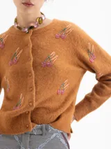 Cardigan de punto color marrón, con cuello redondo, cierre frontal de botones y mangas largas. Presenta un diseño bordado con motivos de cerezas realizados en canutillos.