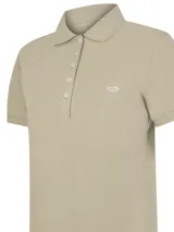 Remera tipo polo de piqué color beige, con cuello camisero, cierre frontal de botones y manga corta. Presenta un pequeño bordado del logo de la marca en el pecho.